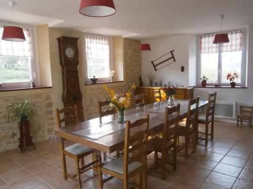 la chomiarde في Saint-Médard-de-Presque: غرفة طعام مع طاولة وكراسي وساعة