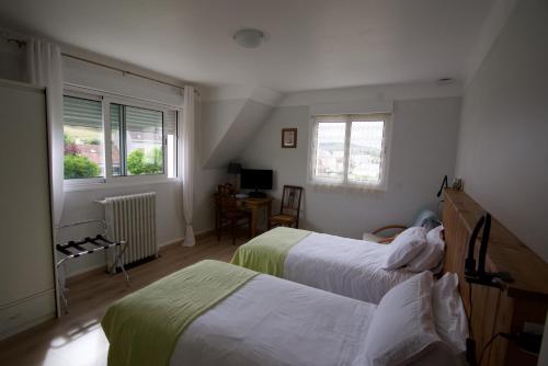 sypialnia z 2 łóżkami, biurkiem i oknami w obiekcie Au Jardin Saint Laurent w mieście Eu