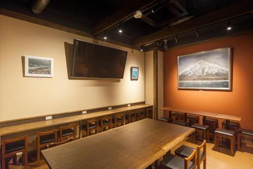 a conference room with a table and a screen on the wall at Kanazawa Capsule Hotel Musashimachi in Kanazawa