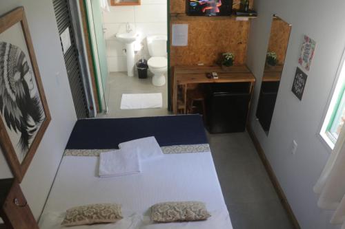a room with a bed and a bathroom with a toilet at Alma Brava in Itajaí