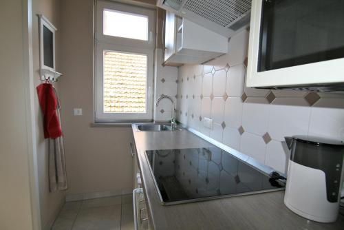 uma pequena cozinha com um lavatório e uma janela em FeWo Schweriner Altstadt em Schwerin