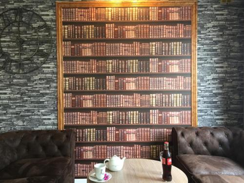 ściana książek w bibliotece ze stołem w obiekcie Kyriad Lisieux w mieście Lisieux