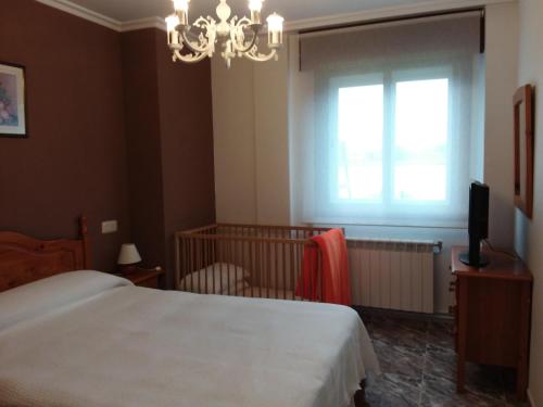 um quarto com uma cama, uma janela e uma televisão em Apartamentos Barrosa no Portonovo