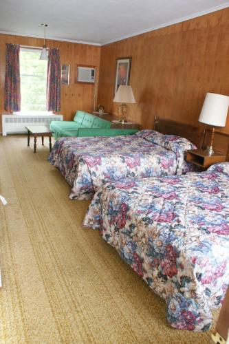 a hotel room with two beds and a couch at Northern Peaks Motor Inn in Gorham