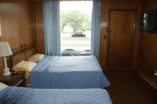 a hotel room with two beds and a window at Northern Peaks Motor Inn in Gorham