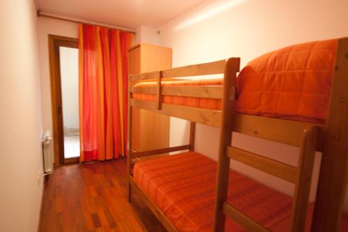 a bedroom with two bunk beds with an orange mattress at Can Marxant, céntrico, servicios al lado y cruce de senderos in Molló