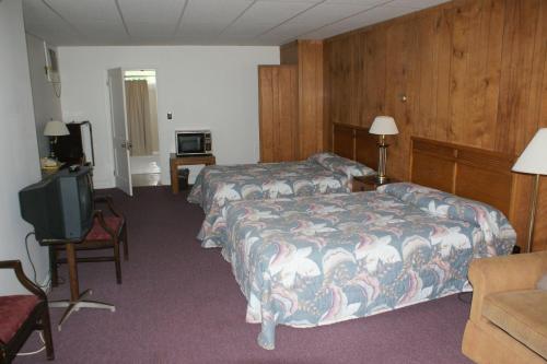 a hotel room with two beds and a television at Northern Peaks Motor Inn in Gorham