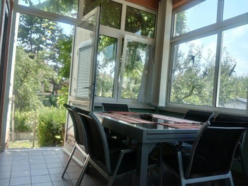 une véranda avec une table et des chaises dans l'établissement Gîte 