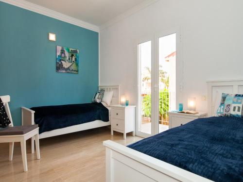 マスパロマスにあるCurie with Pool by VillaGranCanariaの青い壁のベッドルーム1室、ベッド1台、テーブルが備わります。