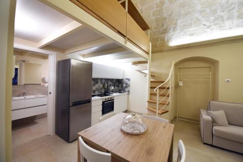 a kitchen with a wooden table in a room at Antica Dimora Storica La Finestra Sul Campanile in Matera