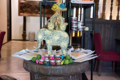 a table with a statue of an elephant on it at Risasinee Spa & Resort in Nan