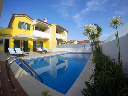 a villa with a swimming pool in front of a house at FlowerHouse in Sintra