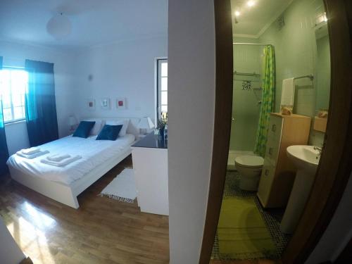 um quarto com uma cama e uma casa de banho em FlowerHouse em Sintra
