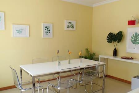 a dining room with a white table and chairs at FlowerHouse in Sintra