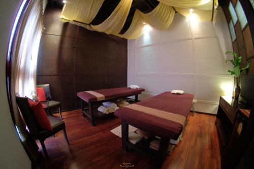 a room with a bed and a table and chairs at Risasinee Spa & Resort in Nan