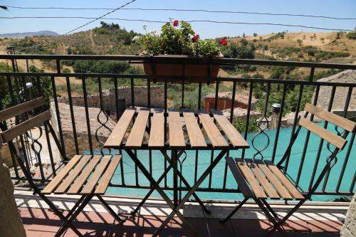 einen Tisch und zwei Stühle auf einem Balkon mit einer Pflanze in der Unterkunft La Locanda Di Cadì in Petralia Soprana