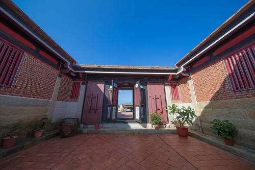 an entry to a brick building with a red door at Patio Moonlight in Jincheng