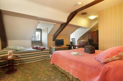 a hotel room with two beds and a television at Hotel De Gramont in Pau