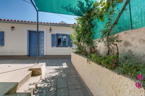 a house with a blue door and some flowers at Apartments Relax in Veli Lošinj