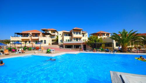 a large swimming pool in front of some apartments at Aloni Suites in Chorafakia