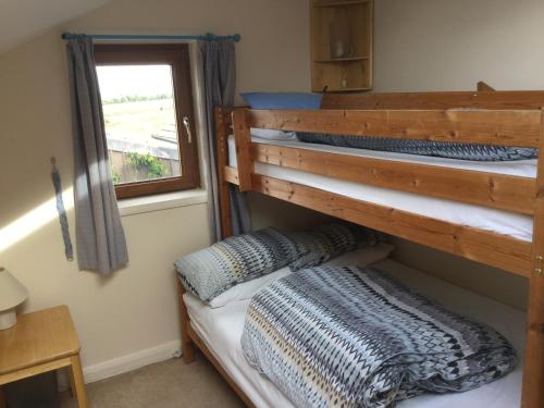 two bunk beds in a room with a window at Lazy Daisys in Langsett