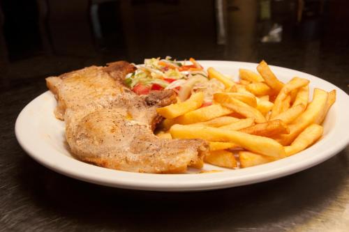 a plate of food with french fries and meat at Hospedaje Yarisnori in Bocas del Toro