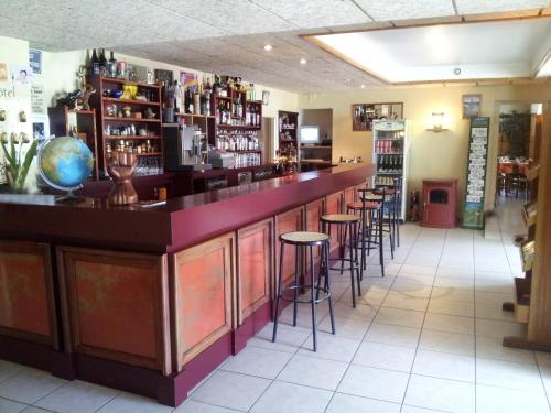 a bar in a restaurant with stools at Hotel de France in Chaudeyrac