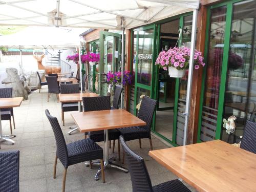 a restaurant with tables and chairs and flowers at Hotel de France in Chaudeyrac