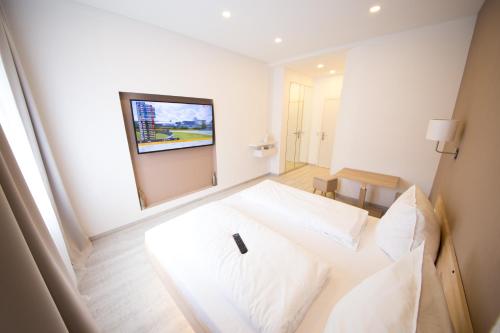 a bedroom with a white bed and a mirror at L-DOM in Metzingen