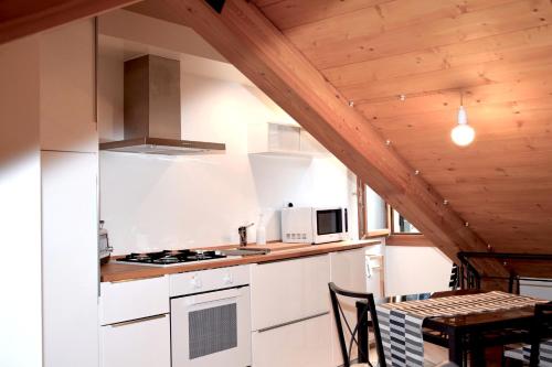 ヴェネツィアにあるMarty Guest House Veneziaの木製の天井、白い家電製品付きのキッチン