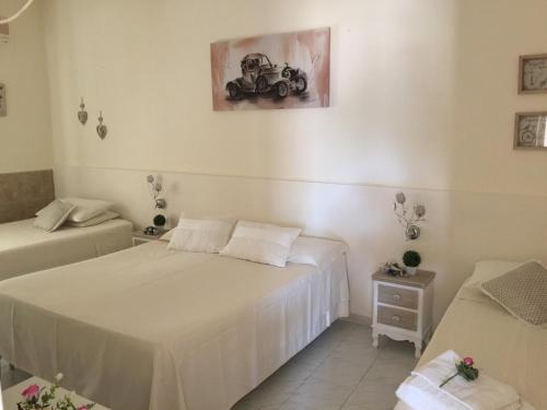 a bedroom with two beds and a picture of a car on the wall at B&B Villa Cassandra in Castellana Grotte