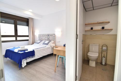 1 dormitorio con cama, escritorio y aseo en Apartamento Soho, en Málaga