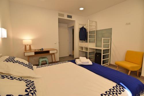 マラガにあるApartamento Sohoのベッドルーム1室(ベッド2台、デスク、椅子付)
