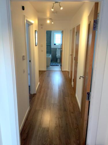 a hallway of a home with wooden floors and a bathroom at Ventoux in Aviemore