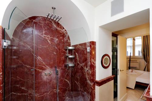 a bathroom with a shower with a red marble wall at Boccaccio 22 in Rome