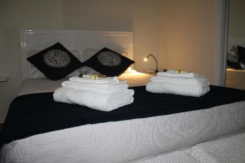 two stacks of towels sitting on top of a bed at Ar Puro II in Viana do Castelo