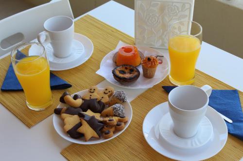 a table with plates of food and two glasses of orange juice at Ar Puro II in Viana do Castelo