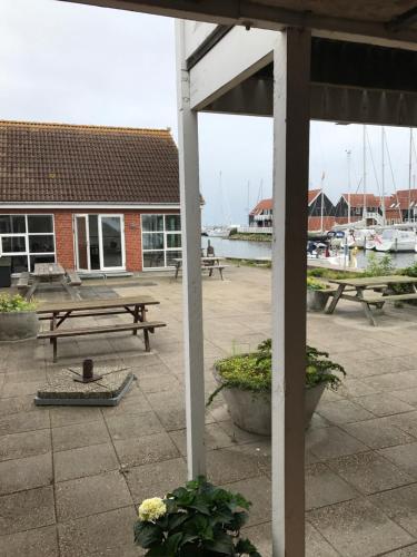 a patio with a picnic table and benches and a marina at Klintholm Marina Park Cabins in Borre