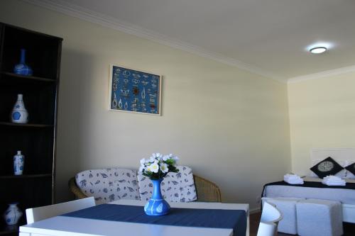 eine blaue Vase mit Blumen auf einem Tisch in einem Zimmer in der Unterkunft Ar Puro II in Viana do Castelo