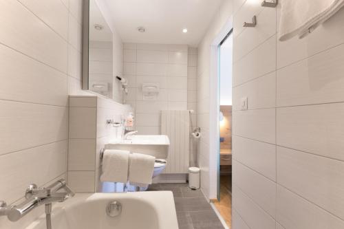 een witte badkamer met een wastafel en een toilet bij Hotel Bristol in Zermatt