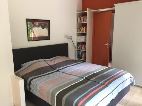 1 dormitorio con cama y estante para libros en B&B Cantecleer Vught, en Vught