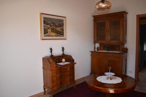 a room with a wooden cabinet and a table at La Solatìa in Porto Ceresio