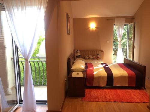 a bedroom with a bed and a large window at Villa Julia in Petrovac na Moru