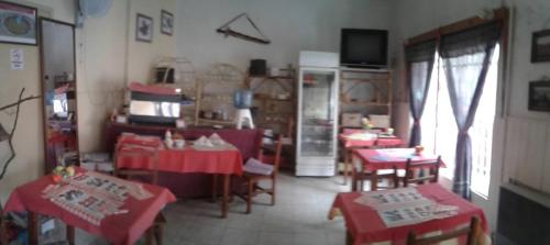 a living room with red tables and chairs and a television at Residencial Marluc in Río Cuarto
