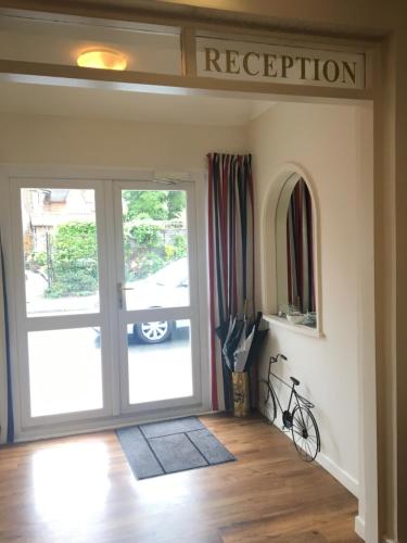 a room with a door with a sign that reads reception at Penny Farthing Hotel & Cottages in Lyndhurst