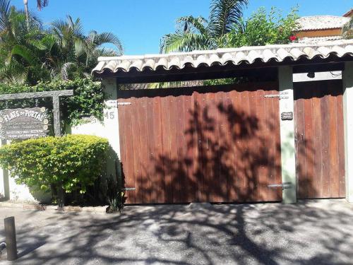 una valla de madera con una puerta en un patio en Flats do Portal, en Búzios