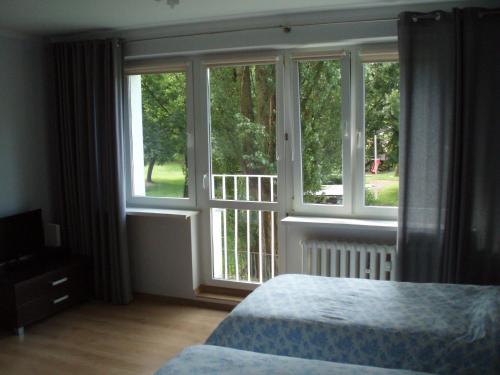 a bedroom with a bed and a large window at Budget Stay in Szczecin