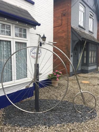 a large metal sculpture in front of a house at Penny Farthing Hotel & Cottages in Lyndhurst