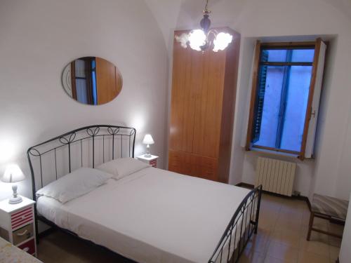 a bedroom with a bed and a mirror and a window at La casa sul mare in Riva Ligure