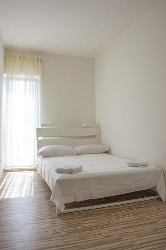 a white bedroom with a large bed in a room at Rezidencija AB in Pag